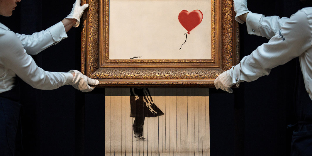 班克斯，《爱在垃圾桶》，2018，自喷漆、丙烯颜料、画布、木板，40 x 31 x 7''. 摄影：Jack Taylor/Getty Images.