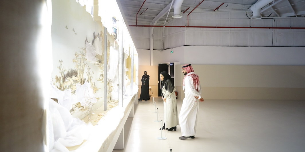 观众在欣赏迪里耶当代艺术双年展上徐冰的作品《背后的故事：溪山无尽图》（2013）. 图片：Canvas and Diriyah Biennale Foundation.