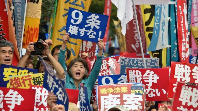 抗议者在东京国会议事堂前抗议安倍晋三的新安保法案，2015年9月18日. AFP PHOTO / KAZUHIRO NOGI.