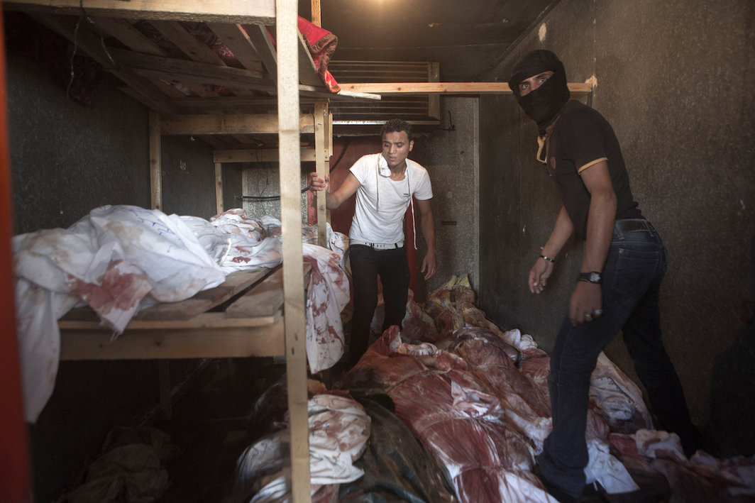 尸体被存放在一个原本用来存放蔬菜和花卉的冷藏空间里，在以色列对拉法赫市（Rafah）轰炸过后，附近的科威特医院已经没有充足的空间停放尸体，2014年8月3日. 摄影：安·帕克