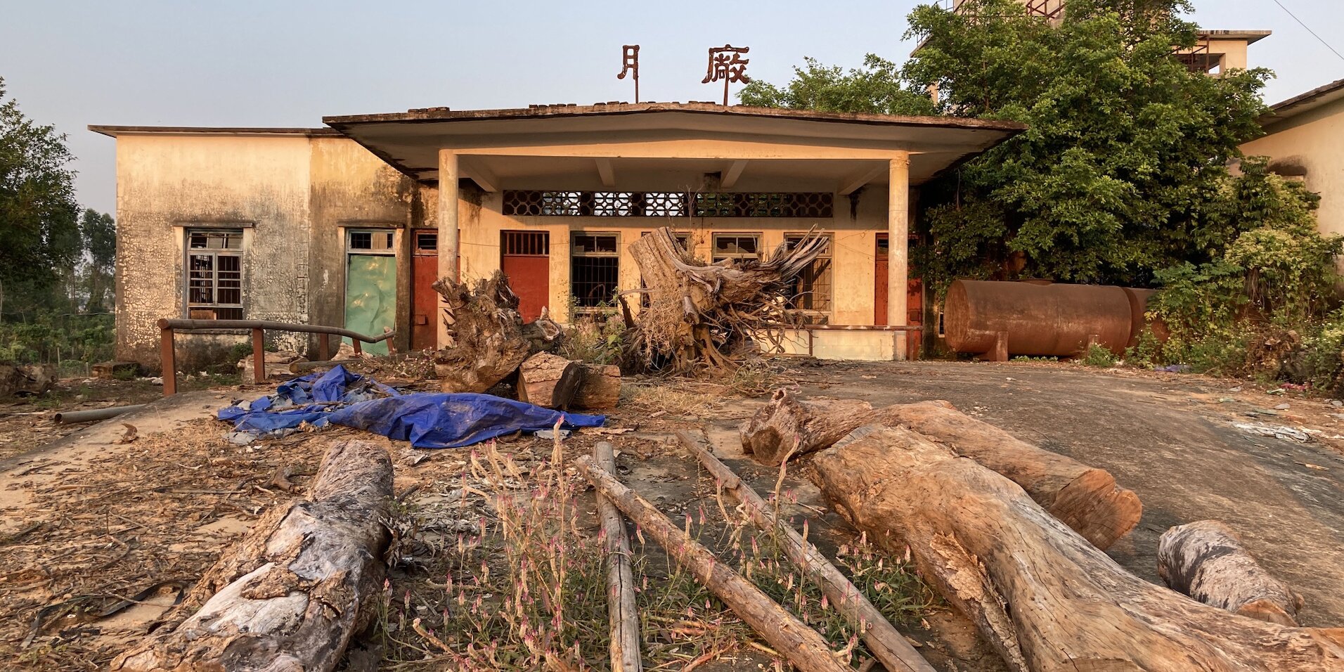 悬浮在湛江奋勇华侨农场被废弃的橡胶厂房上的大型招牌，原本“膠廠”两字的部分文字已经脱落，变成“月廠”，2023. 图片提供：菠萝核.